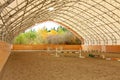 Covered open horse arena with sand.