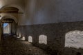 A covered passage inside the castle of Torrechiara, Parma, Italy, from whose windows the sun filters Royalty Free Stock Photo