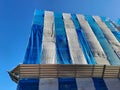 Covered scaffolding by a building under renovation Royalty Free Stock Photo