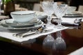 Covered served dinner table with expensive white dishes and glasses