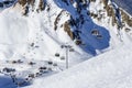 Covered with snow Aibga cirque ski slopes and chair ski lifts in Gorky Gorod winter mountain resort. Skiers ride on ski lifts on s