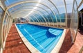 Covered summer pool with a blue tile. The covered area of the outdoor pool for hotel. Water retains heat longer and protect from