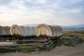 Covered wagons in yard at ranch in Yellowstone park with sky in background