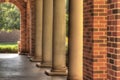 Covered walkway bordered with yellow columns and brick supports