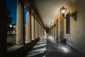 Covered walkway or stoa with Greek columns and lanterns at night. Royalty Free Stock Photo