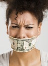 Covering mouth with a dollar banknote