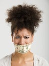 Covering mouth with a dollar banknote