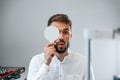 Covering right eye. Man is checking his vision indoors in the clinic Royalty Free Stock Photo