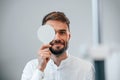 Covering right eye. Man is checking his vision indoors in the clinic Royalty Free Stock Photo