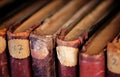 Covers of antique books on vintage bookshelves with old volumes of a library