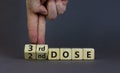 Covid-19 booster dose vaccine shot symbol. Doctor turns cubes and changes words `2nd dose` to `3rd dose`. Beautiful grey