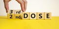 Covid-19 booster dose vaccine shot symbol. Doctor turns cubes and changes words `2nd dose` to `3rd dose`. Beautiful white