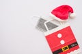 Covid-19 in Christmas festival celebration concept. Flat lay of red santa claus hat and protective face mask in gift bag Royalty Free Stock Photo