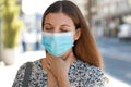 COVID-19 Close up Woman wearing surgical mask with sore throat outdoor. Portrait of woman with face mask against SARS-CoV-2