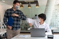 Covid-19 concept Coronavirus two male colleagues wearing protective face masks greeting bumping elbows at office protecting from Royalty Free Stock Photo