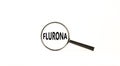 Covid-19 corona and flu flurona symbol. The concept word flurona. Magnifying glass. Beautiful white table, white background.