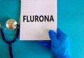 Covid-19 corona and flu flurona symbol. Hand in blue glove with white note. The concept word Flurona. Stethoscope. Medical and