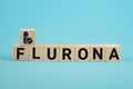 Covid-19 corona and the symbol flu flurona. Wooden cube concept word flurona on blue background. Medicine, Covid-19