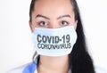 Covid-19 coronavirus desease global pandemic outbreak. A young female doctor in a medical mask with lettering. Close up portrait f