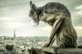 COVID-19 coronavirus in France, medical mask on gargoyle of Notre Dame in Paris. Tourist landmarks closed due to corona virus Royalty Free Stock Photo