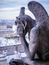 COVID-19 coronavirus in France, surgical mask on gargoyle of Notre Dame in Paris Royalty Free Stock Photo