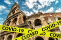 COVID-19 coronavirus in Italy, caution tape in photo of Colosseum in Rome. World tourist landmarks closed due to SARS-CoV-2 corona Royalty Free Stock Photo