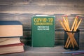COVID-19 CORONAVIRUS, PREVENTIVE HEALTHCARE. Book on a wooden background
