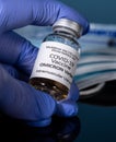 Close up of bottle of new Covid-19 vaccine for Omicron variant wtih gloved hand Royalty Free Stock Photo