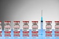 Covid-19 Coronavirus Vaccine red vials in a row with a syringe