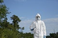 Covid-19 Coronavirus virus. A man in protective clothing in a white overalls disinfects and decontaminates in public places Royalty Free Stock Photo