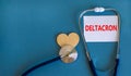 Covid-19 deltacron variant symbol. The concept word deltacron on wooden block and stethoscope. Wooden heart. Beautiful blue