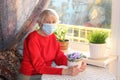 The Covid-19, health, safety and pandemic concept - senior old lonely woman sitting near the window Royalty Free Stock Photo