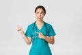 Covid-19, healthcare workers, pandemic concept. Skeptical and doubtful pretty asian doctor, nurse in scrubs smirk Royalty Free Stock Photo