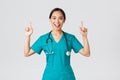 Covid-19, healthcare workers, pandemic concept. Smiling cheerful pretty nurse, female doctor or intern in scrubs Royalty Free Stock Photo