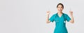 Covid-19, healthcare workers, pandemic concept. Smiling cheerful pretty nurse, female doctor or intern in scrubs Royalty Free Stock Photo