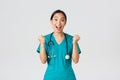 Covid-19, healthcare workers and preventing virus concept. Hopeful and relieved, joyful asian pretty female doctor