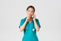 Covid-19, healthcare workers and preventing virus concept. Portrait of smiling asian female doctor, intern in scrubs