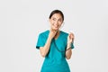 Covid-19, healthcare workers and preventing virus concept. Smiling cute asian doctor, female nurse examine patient lungs Royalty Free Stock Photo