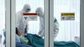 Covid-19 infected patient on bed in quarantine room with quarantine and breakout alert sign at hospital with disease control