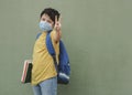 Covid-19,kid with medical mask and backpack going to school doing victory sign