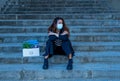 Sad woman in face mask with office box feeling hopeless after losing job due to coronavirus job cuts