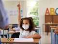 Covid, learning and education with a young girl student wearing a mask and raising her hand to ask or answer a question Royalty Free Stock Photo