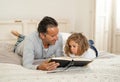 COVID-19 Lockdown. Father and cute little daughter reading a book together in self isolation Royalty Free Stock Photo