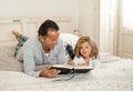 COVID-19 Lockdown. Father and cute little daughter reading a book together in self isolation Royalty Free Stock Photo
