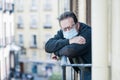 Covid-19 lockdown and fear - sad and depressed mature man 65 - 70 years old in virus protective mask at home balcony lonely scared Royalty Free Stock Photo