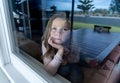 COVID-19 Quarantine. Sad little girl looking through the window feeling lonely during lockdown Royalty Free Stock Photo