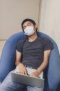 Covid-19, Man wearing face mask sleeping on sofa with laptop computer, Wearing a face mask to protect against coronavirus, busines Royalty Free Stock Photo