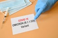 Covid-19 new Omicron variant. Doctor hand with blue glove indicate written `Covid-19 variant Omicron` on white paper. Royalty Free Stock Photo