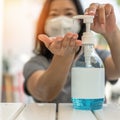Covid-19 outbreak, coronavirus pandemic prevention with woman wearing n95 face mask cleaning hand using alcohol gel sanitizer Royalty Free Stock Photo