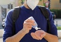 COVID-19 Pandemic Coronavirus Close up Unidentified Man with KN95 FFP2 Mask using Alcohol Gel Sanitizer Hands in City Street.